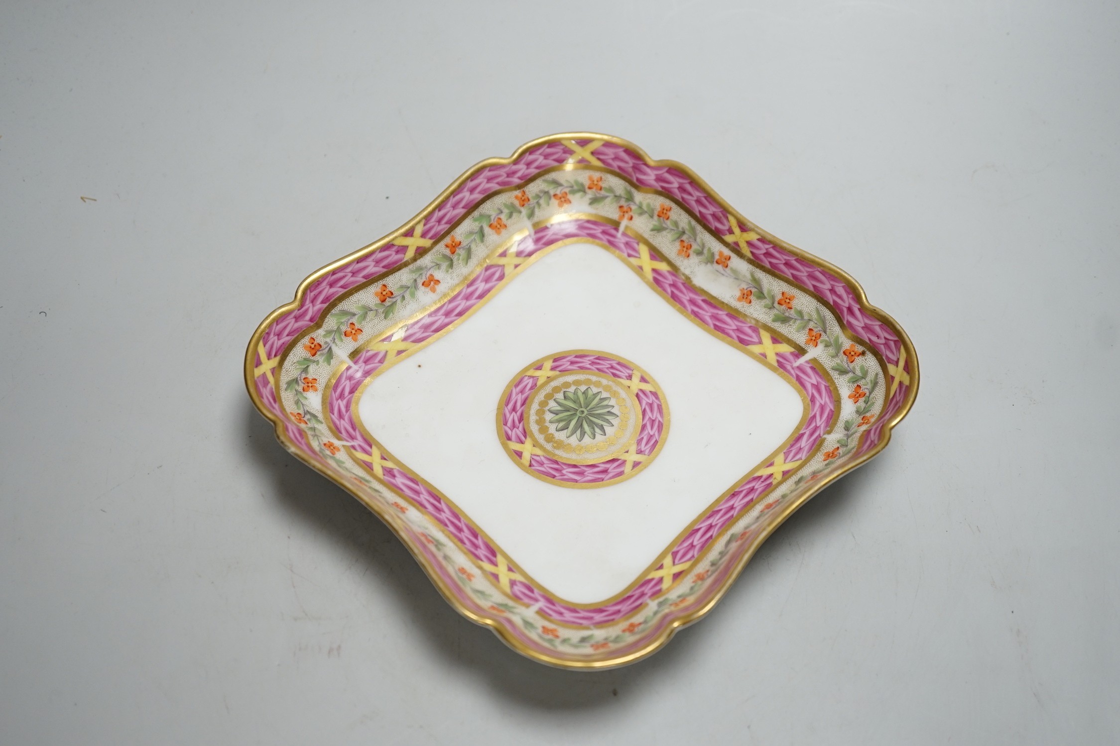 An 18th century Rue Thiroux square shaped dish painted with two bands of pink leaves, and a band of flowers above a central roundel, stencilled crown A mark in orange, the factory was also known as Porcelaines a la Reine